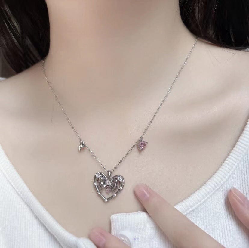 Collier avec pendentif en forme de cœur et nœud papillon